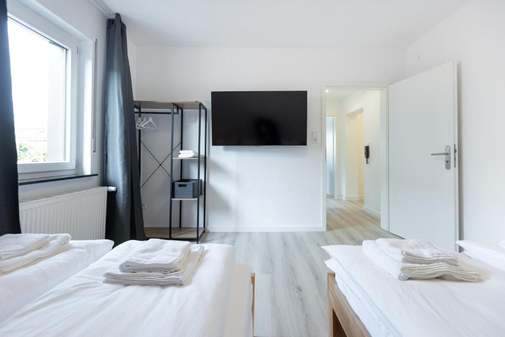 Dieses weiße Zimmer verfügt über 2 Betten und einen Flachbild-TV. in der Unterkunft Apartement in Zell in Zell am Main