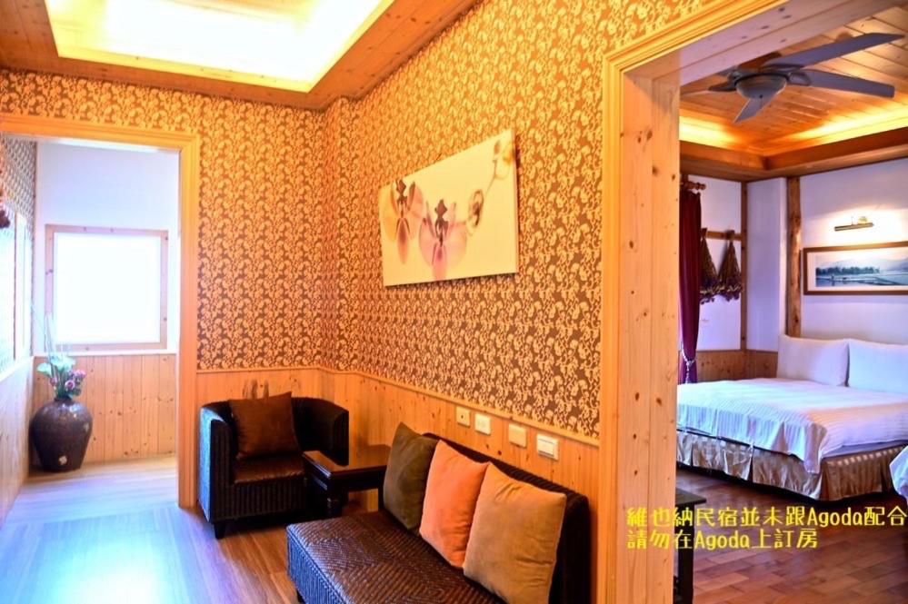 a bedroom with a bed and a couch in a room at Cingjing Vienna Pleasance Cottage in Ren&#39;ai