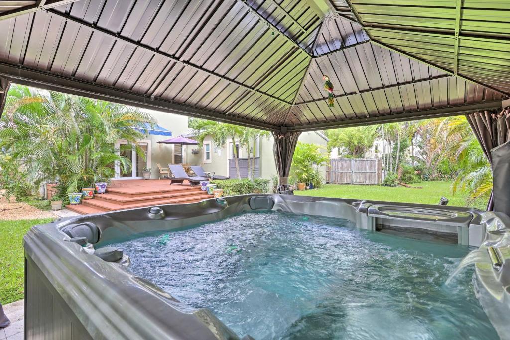 einen Whirlpool im Freien in einem Hinterhof mit Sonnenschirm in der Unterkunft Modern 2 Bd and Loft Getaway Less Than 9 Mi to Dtwn! in Miami