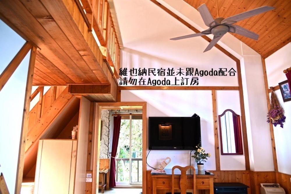 a living room with a ceiling fan and a tv at Cingjing Vienna Pleasance Cottage in Ren&#39;ai