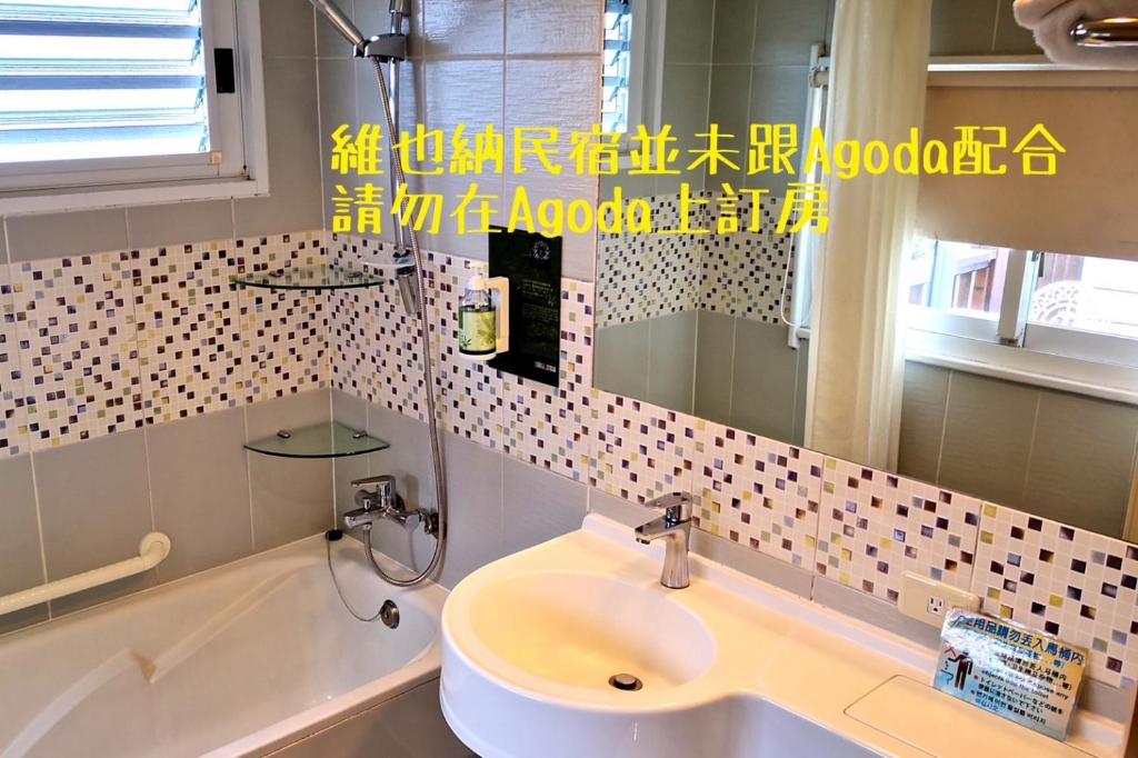 a bathroom with a sink and a tub and a mirror at Cingjing Vienna Pleasance Cottage in Ren&#39;ai