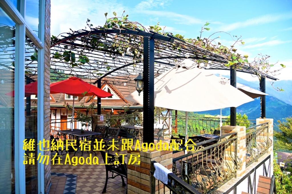 an outdoor patio with an umbrella and an umbrella at Cingjing Vienna Pleasance Cottage in Ren&#39;ai