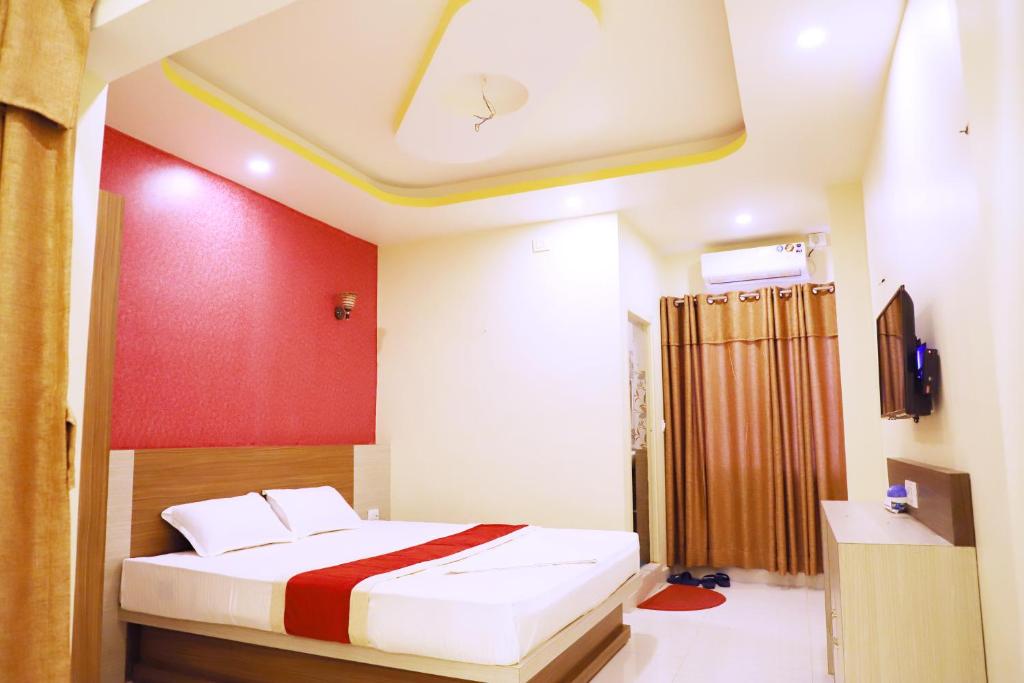 sypialnia z łóżkiem i czerwoną ścianą w obiekcie HOTEL PERFECT PLAZA w Dźanakpur