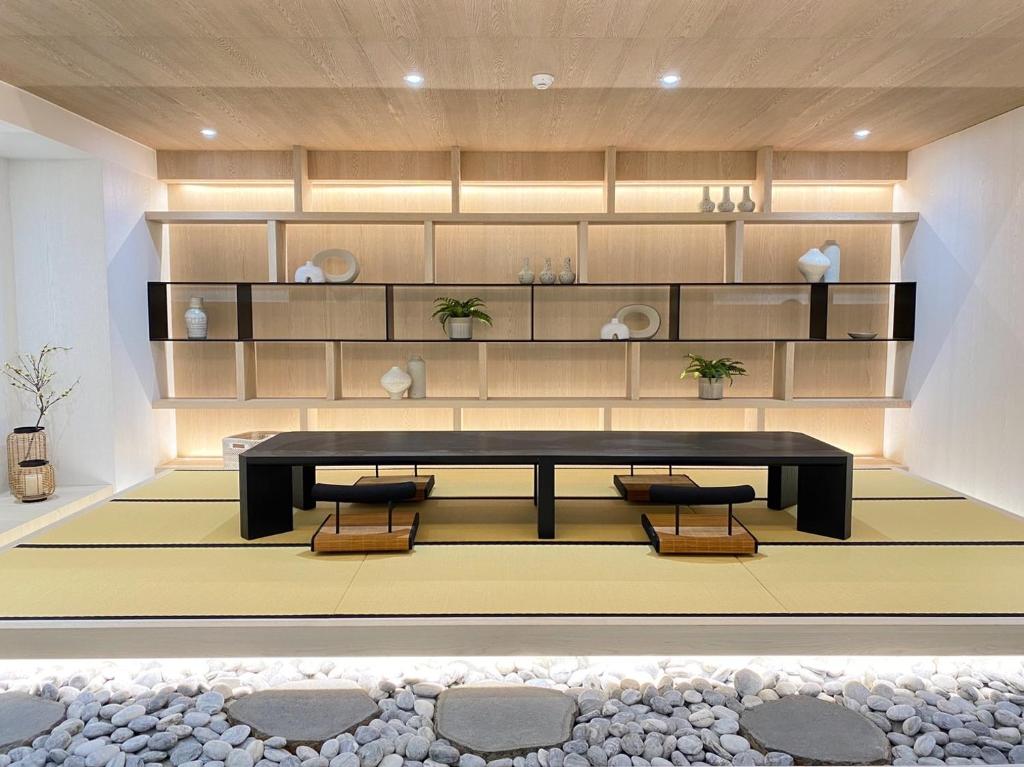 a living room with a table and benches and shelves at suye hotel in Taichung