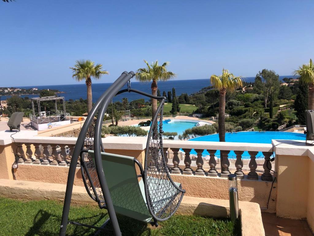- une balançoire en face d'un balcon avec une piscine dans l'établissement Cap Estérel, 2 pièces, jardin, vue mer et piscine, à Agay