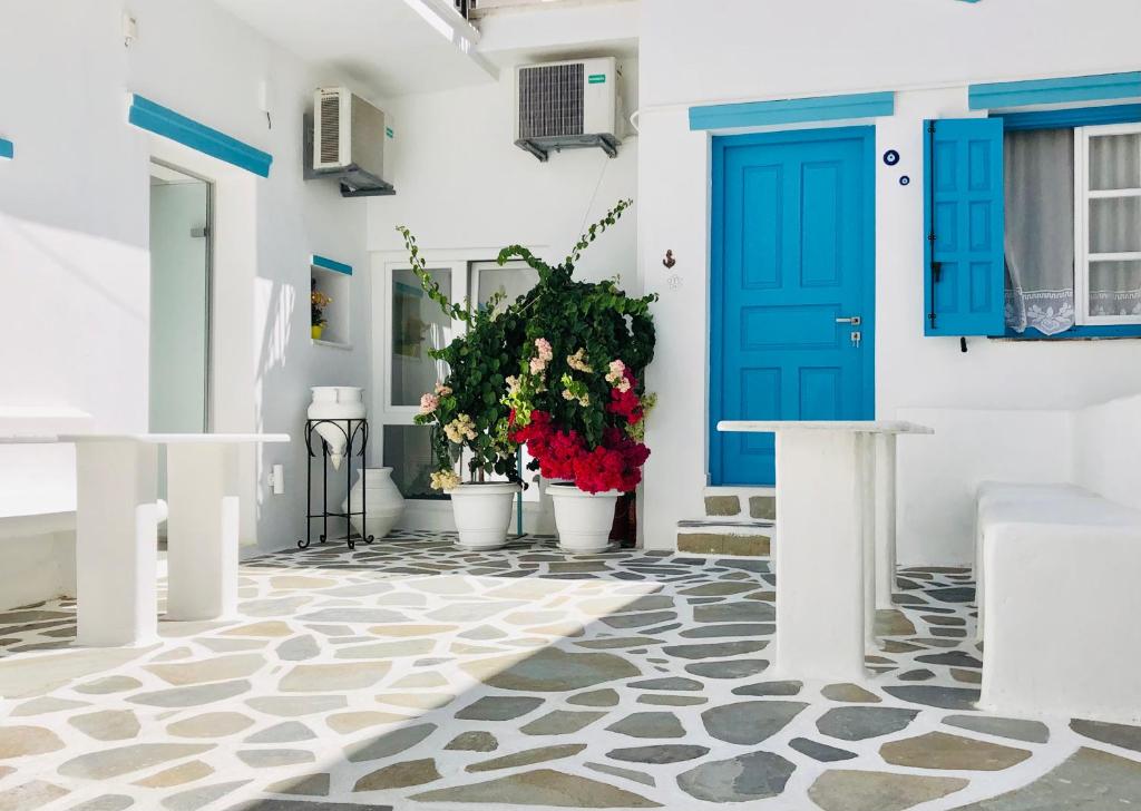une porte bleue sur un bâtiment blanc avec des plantes en pot dans l'établissement Taki's Guests, à Naxos Chora