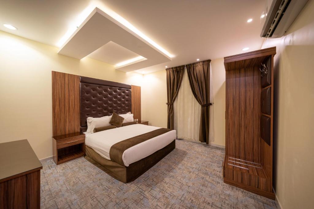 een hotelkamer met een bed en een kast bij The Palace Hotel Suites in Abha
