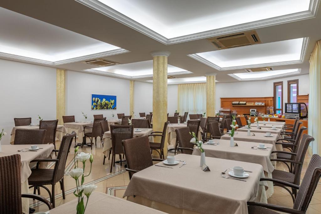 a banquet hall with tables and chairs in a room at Hotel Sabbia d'Oro in San Vito lo Capo