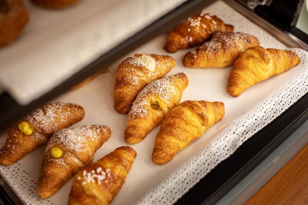 a tray filled with croissants and other pastries at Hotel Sabbia d'Oro in San Vito lo Capo