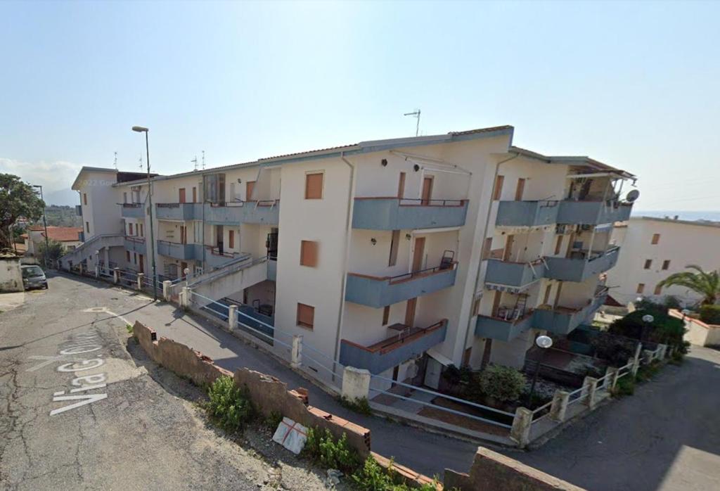 a large apartment building in a parking lot at Аppartamenti per vacanze, 500 m dal mare in Scalea