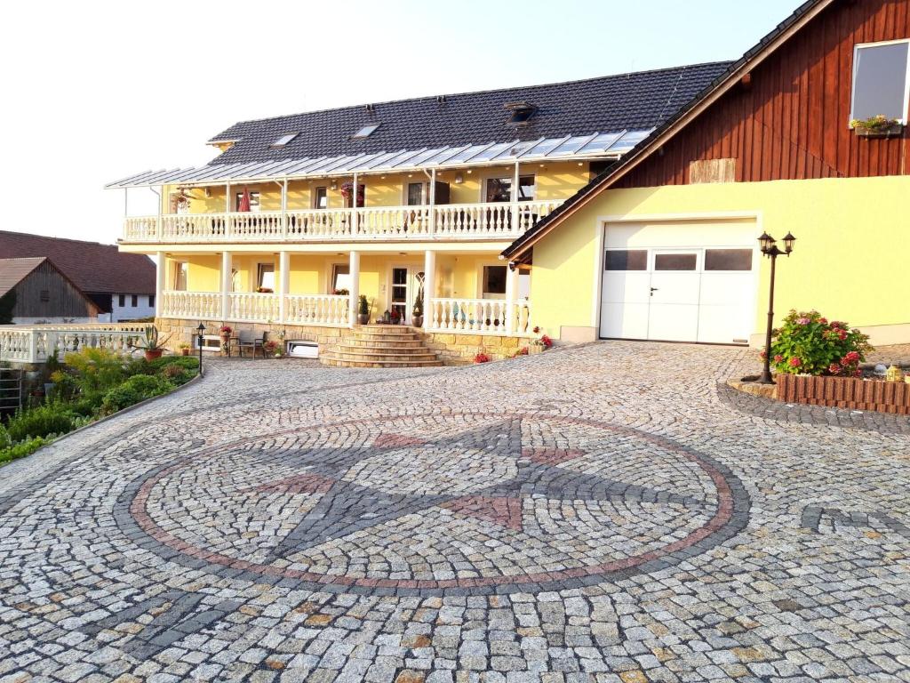 a house with a mosaic on the driveway at Verspielter sächsischer Rückzugsort in Lichtenhain