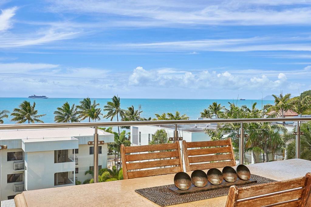 a balcony with a table with a view of the ocean at Stunning 2-3 Bed Penthouse Glorious Ocean Views in Trinity Beach