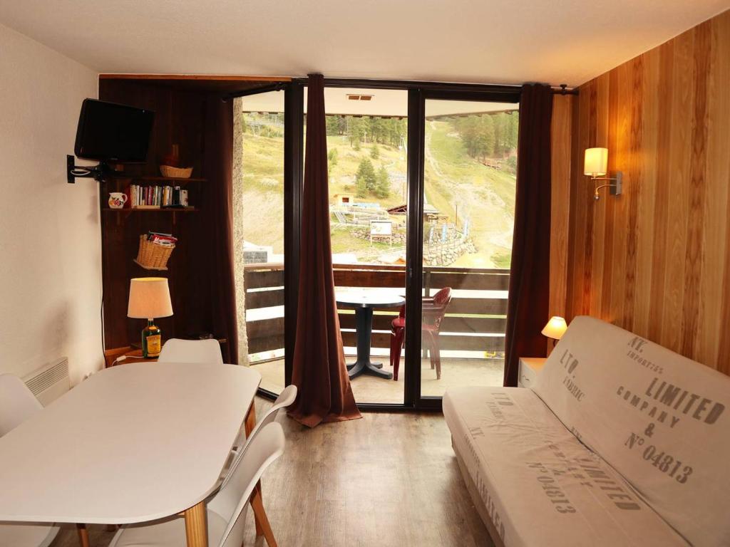 a living room with a table and a couch and a window at Appartement Les Orres, 2 pièces, 6 personnes - FR-1-322-171 in Les Orres