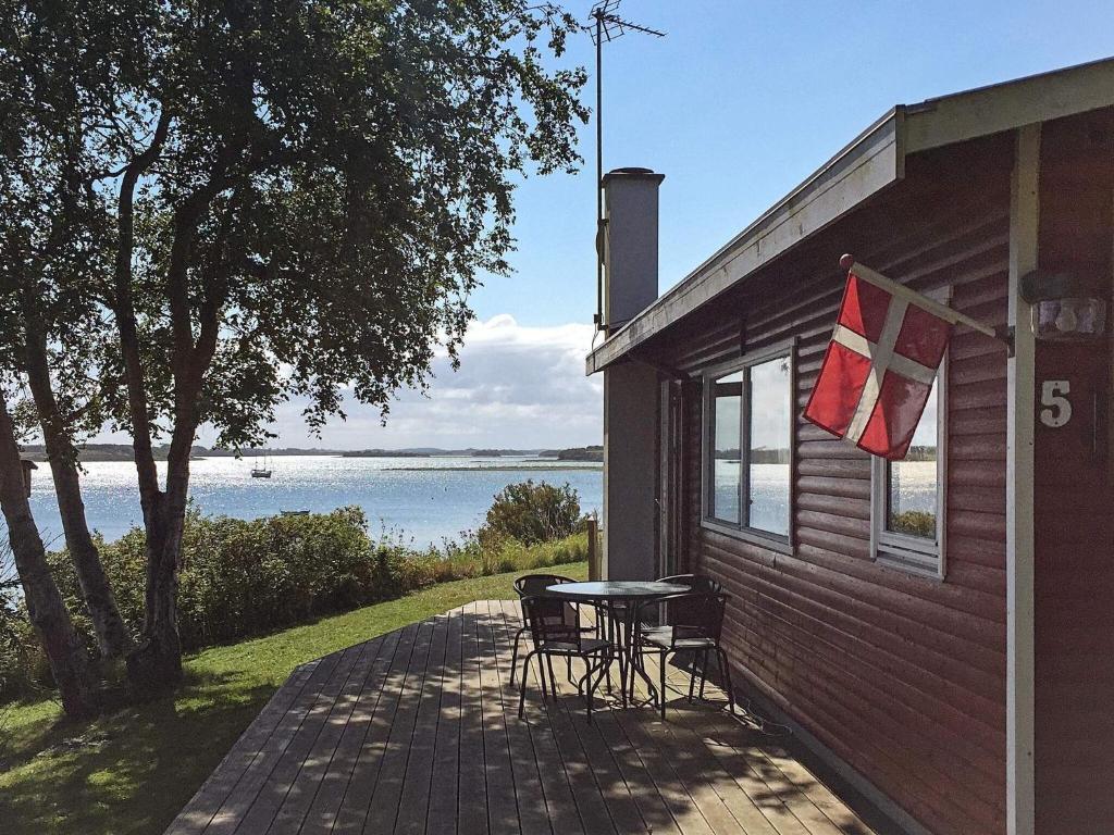 un patio con mesa y sillas en el lateral de una casa en 4 person holiday home in Martofte, en Martofte