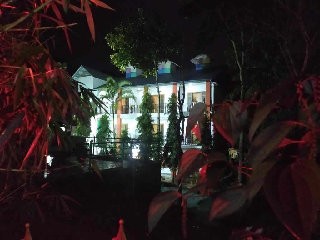 a building with trees in front of it at night at Palliyadiyil Homestay in Thekkady