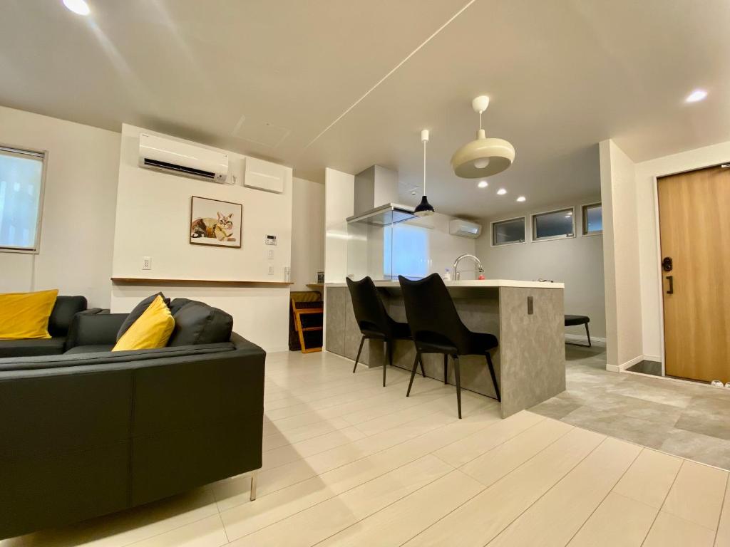 a living room and kitchen with a couch and a table at Villa Monica in Nagoya