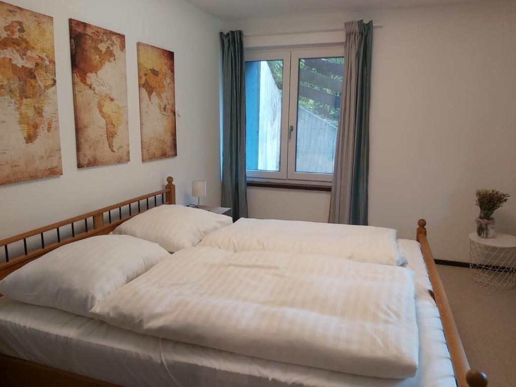 um quarto com uma cama com lençóis brancos e uma janela em Förde Koje em Westerholz