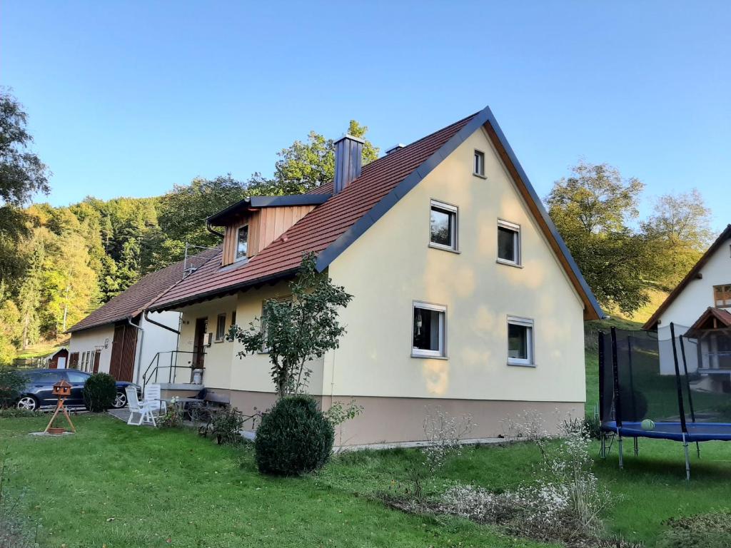 Casa blanca con techo marrón en Ferienhaus Tiefenthal -NICHT FÜR MONTEURE-, en Bad Staffelstein