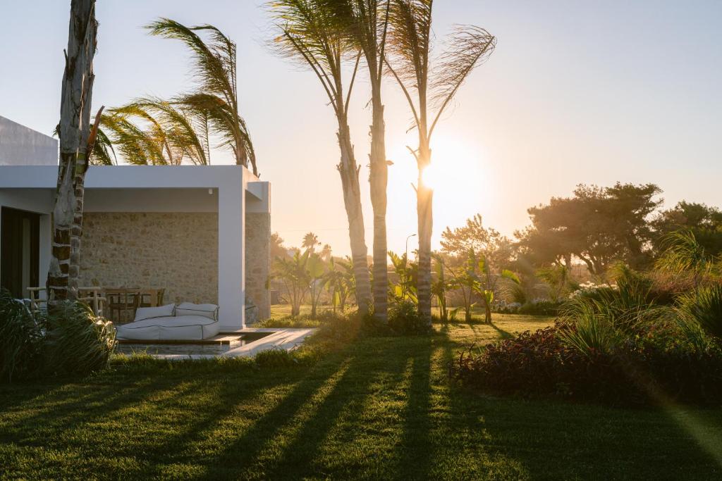 una casa con palmeras en el patio en TAF Beach Villas with Tesla en Tigaki