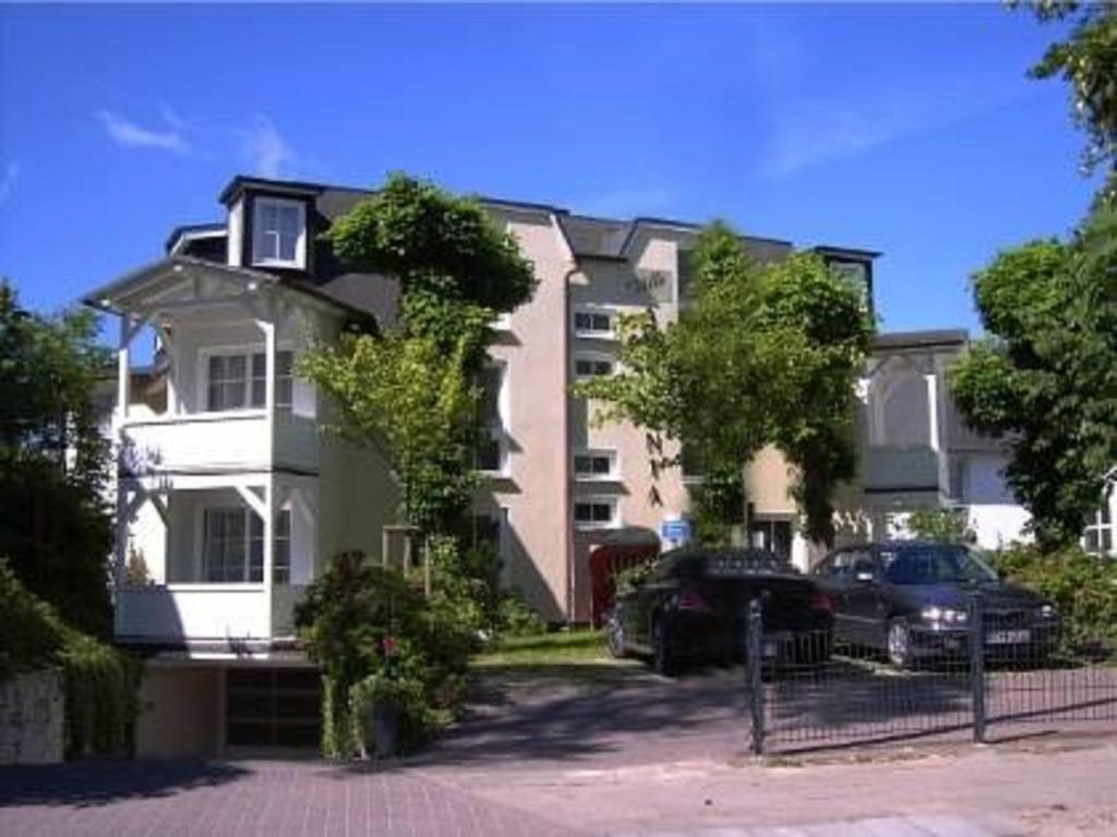 a large building with cars parked in front of it at Villa Ambienta WE 7 in Binz