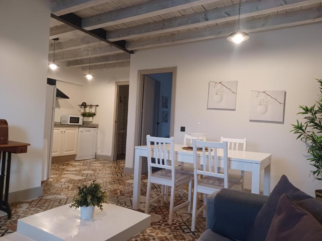 a kitchen and living room with a table and chairs at Apartamentos El Llanin in Cangas de Onís