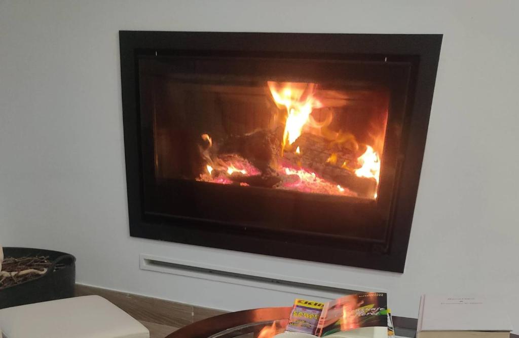 a fireplace in a living room with a fire in it at Villa 28 de julio Casa Rural con piscina en Granada in Granada