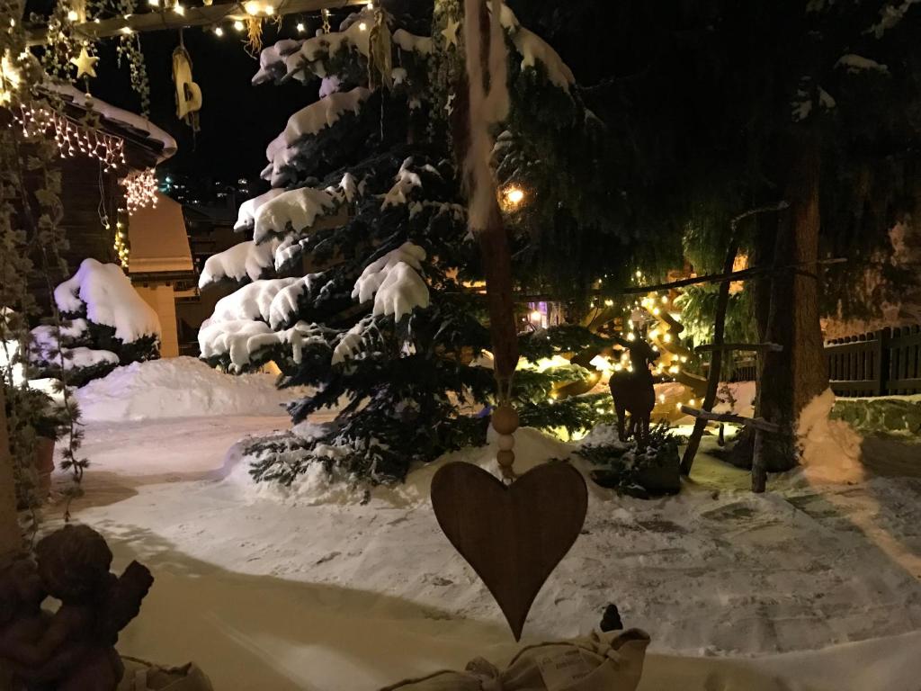 a heart sign in the snow next to a christmas tree at Hotel Romantica in Zermatt