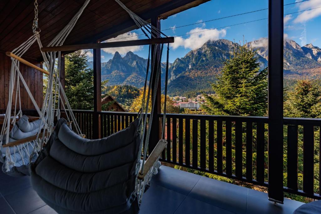 eine Schaukel auf einem Balkon mit Bergen im Hintergrund in der Unterkunft The Bear House 2 in Buşteni