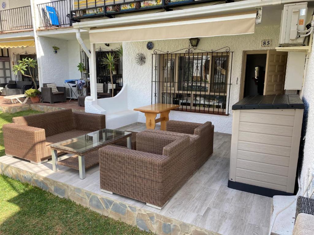 a patio with couches and a table and a grill at Super Holiday Las Buganvillas garden and sea views in Mijas Costa