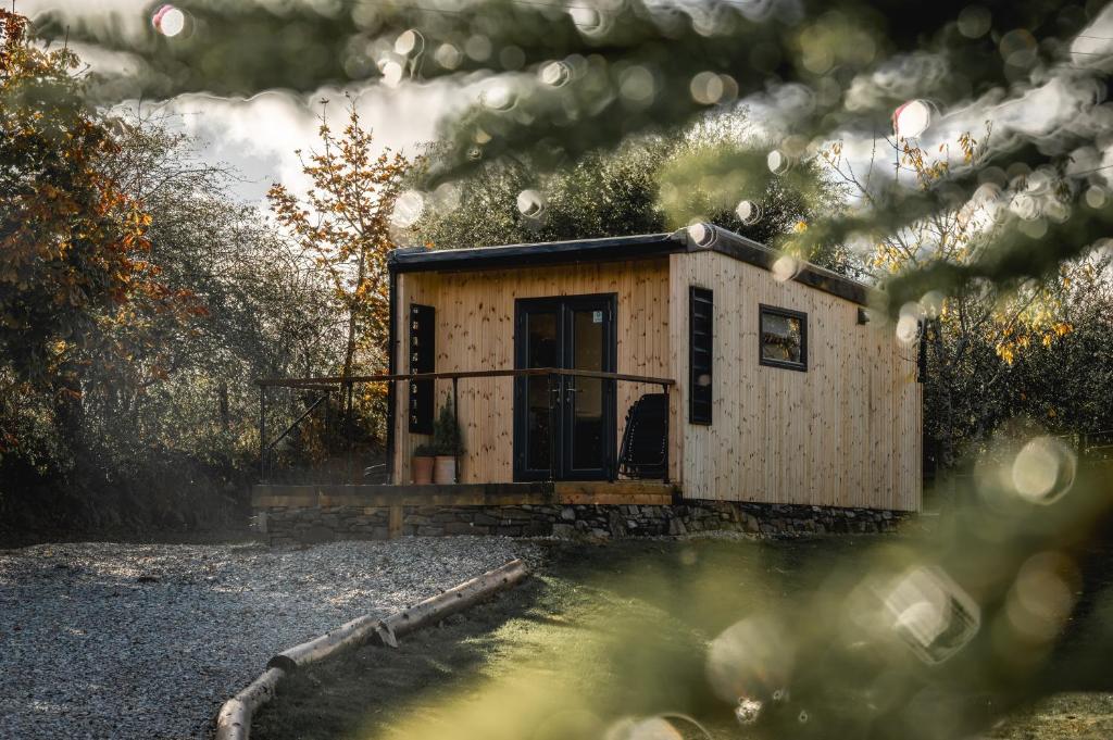 a tiny house sitting on the side of a pond at Coorie In in Kilmore