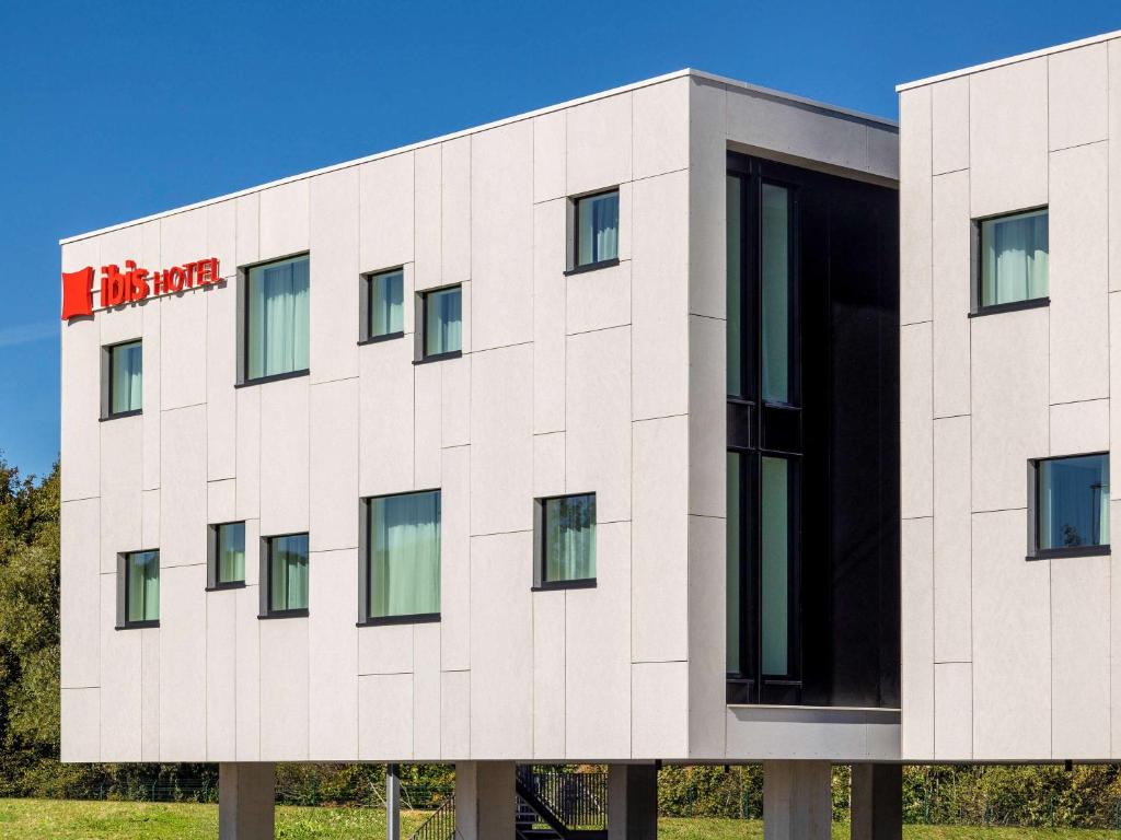 a white building with a red sign on it at ibis Brussels Groot Bijgaarden in Groot-Bijgaarden