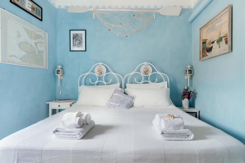 a blue bedroom with a bed with towels on it at B&B La Finestra Sul Campanile in Montecosaro