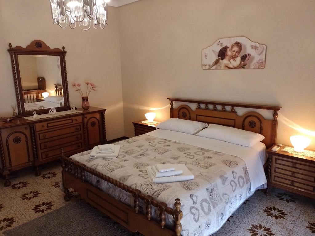 ein Schlafzimmer mit einem Bett mit einem Spiegel und zwei Nachttischen in der Unterkunft Risveglio al Sole in Ragusa