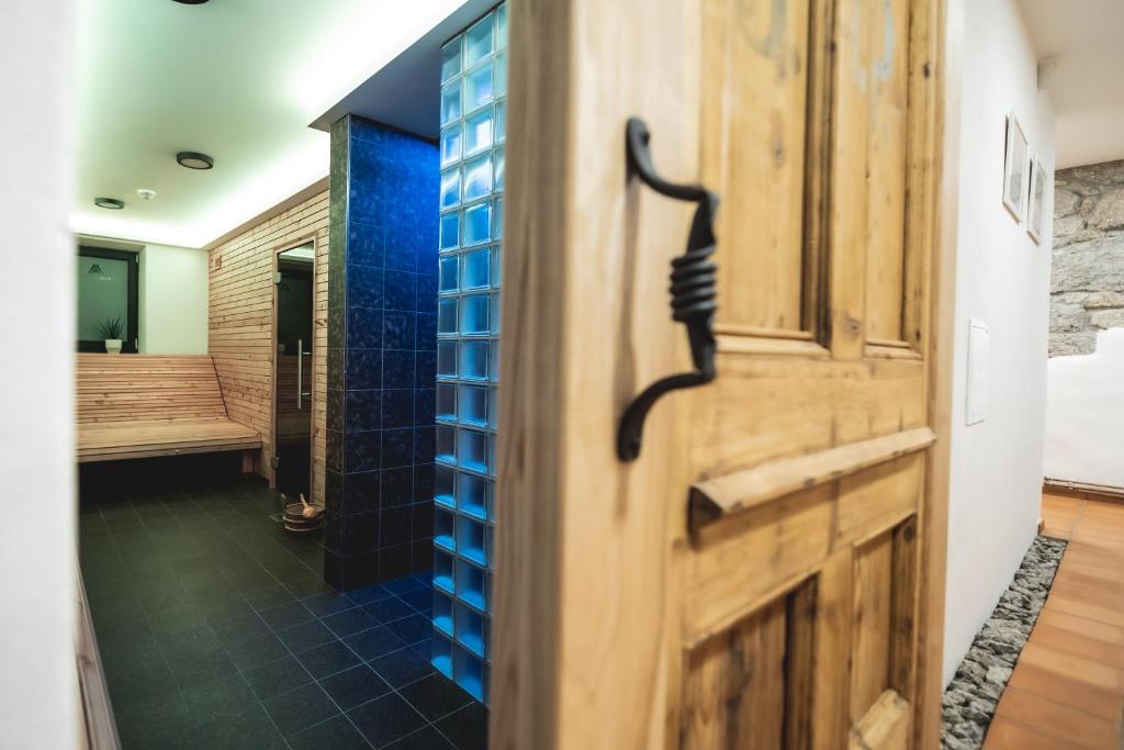 a bathroom with a wooden door with a blue wall at APARTMÁNY MAXOV in Lučany nad Nisou