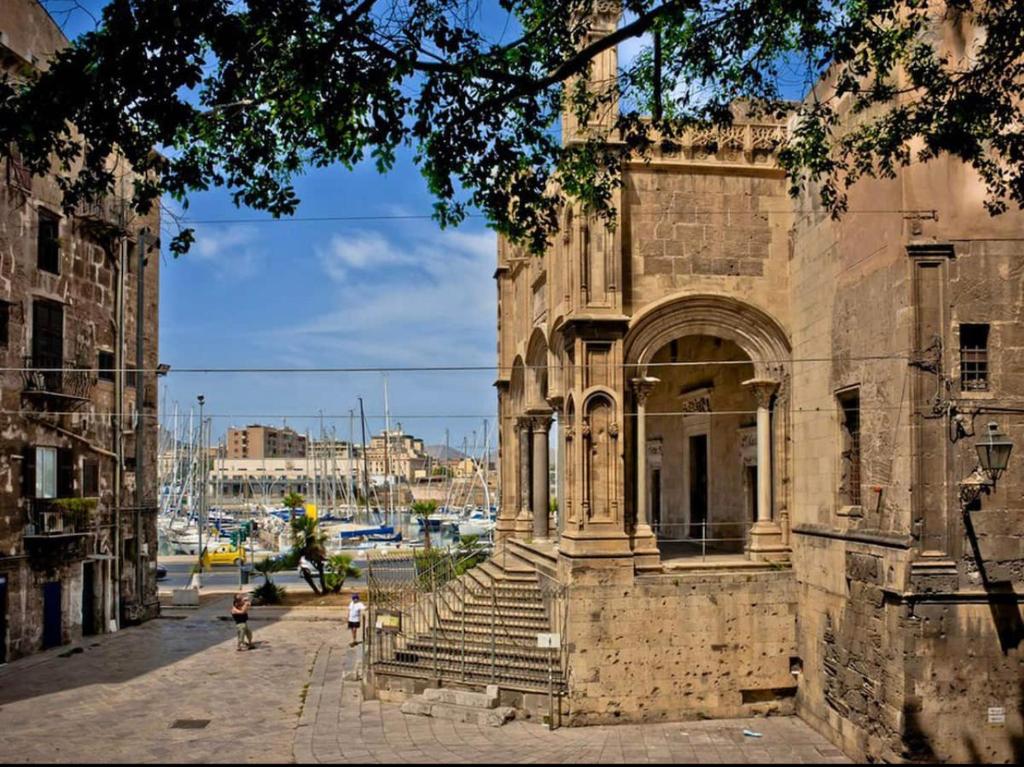 an old stone building with stairs on a street at AR Palace Hotel - Palermo in Isola delle Femmine