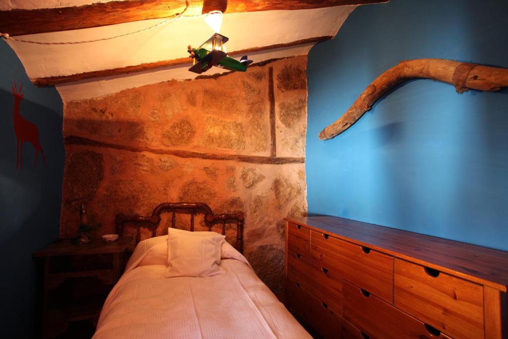 a bedroom with a bed with a wooden ceiling at El Rincón de Bezas in Bezas