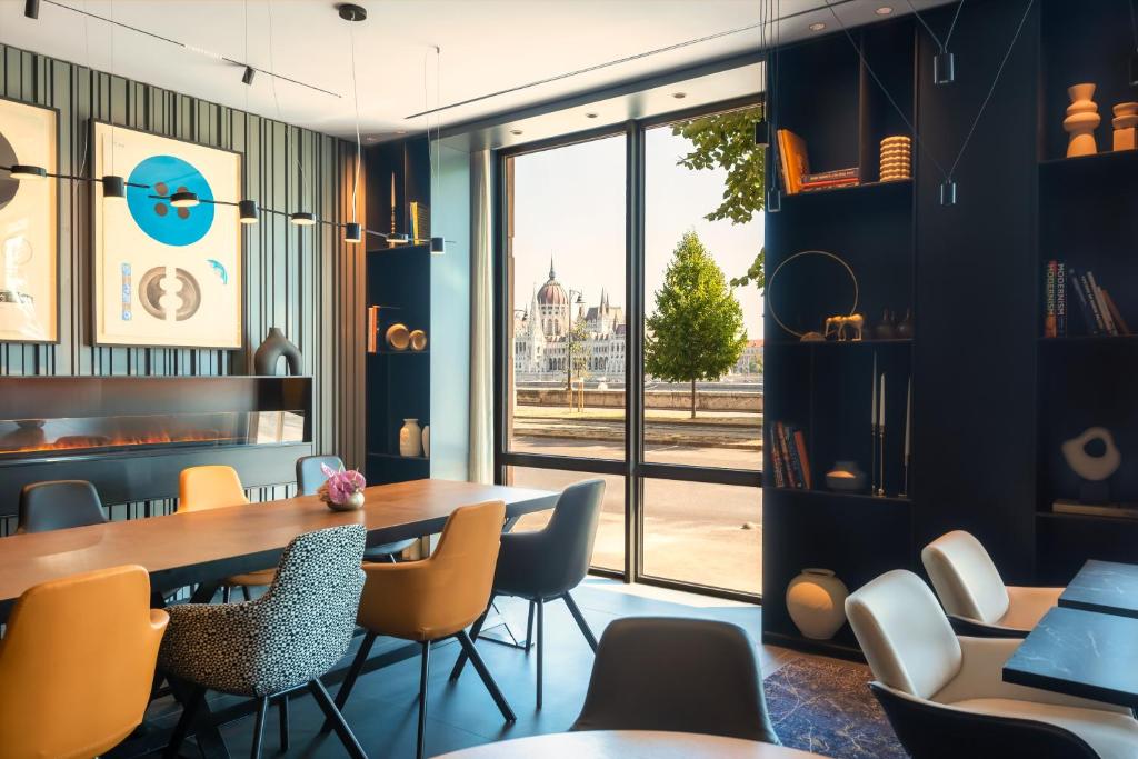 una sala da pranzo con tavolo, sedie e finestra di Park Plaza Budapest a Budapest