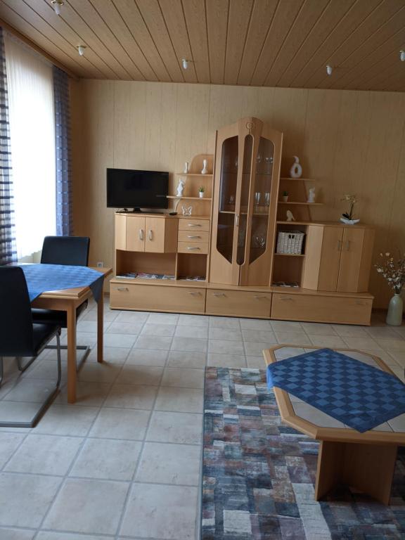 een woonkamer met een tafel en een televisie bij Ferienwohnung Bruss in Saarlouis