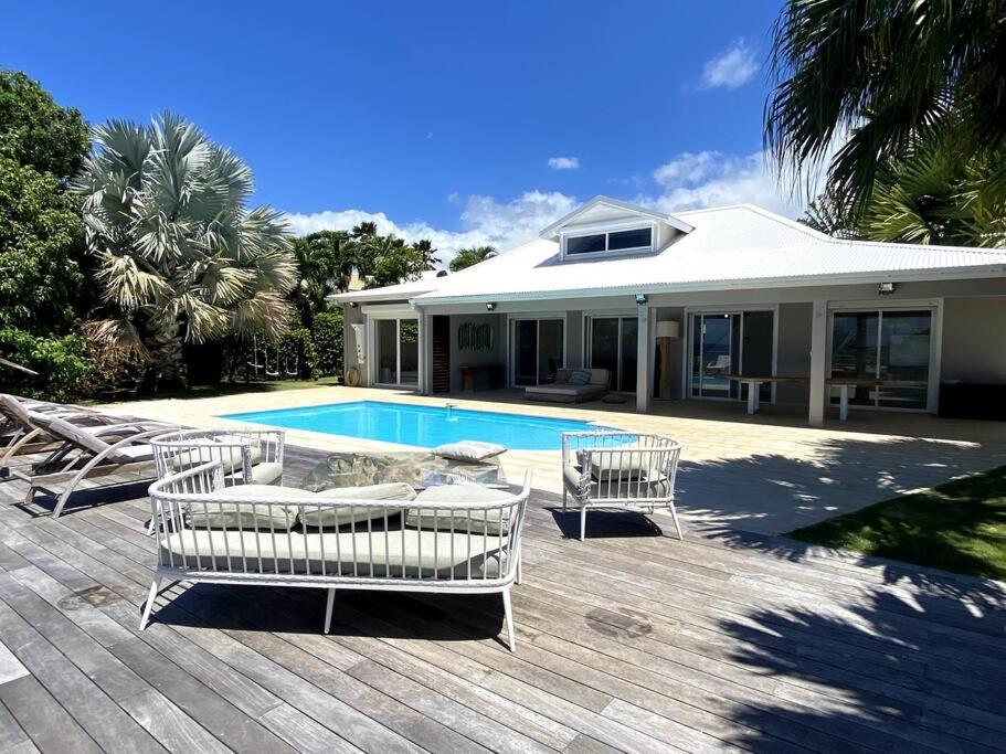 a patio with chairs and a swimming pool at Villa Anse Vinaigri - Plage à pieds in Le Gosier