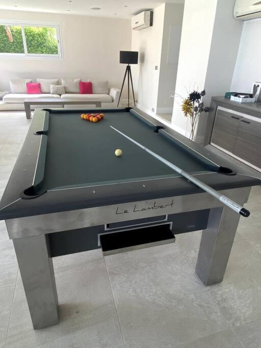 a billiard table with a ball on it in a living room at Villa Anse Vinaigri - Plage à pieds in Le Gosier