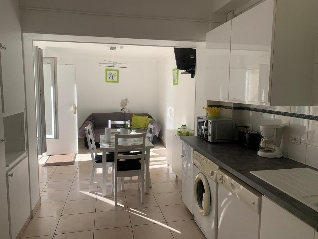 a kitchen with a table and a dining room at Gite Mella in La Courneuve