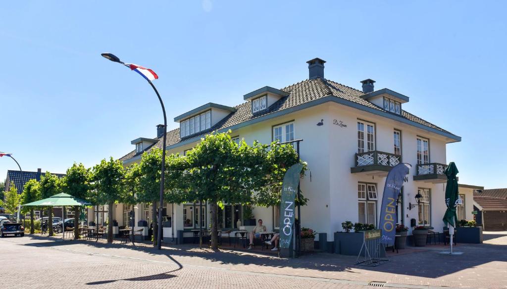 a large white building on the side of a street at Herberg de Zwaan Elspeet in Elspeet