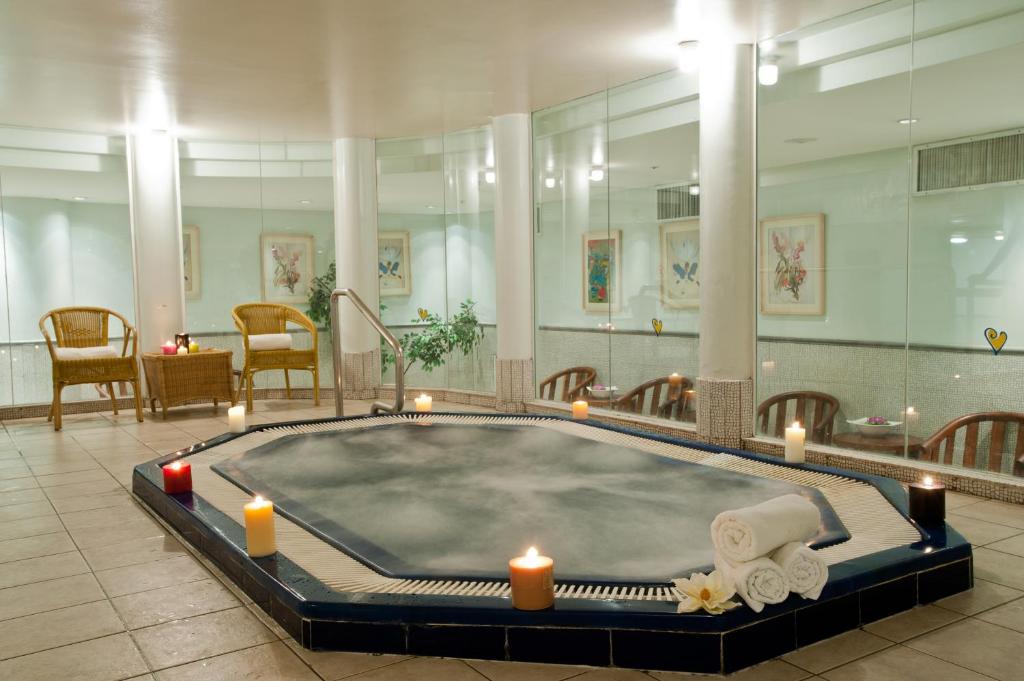 ein Whirlpool in einem Raum mit Kerzen und Stühlen in der Unterkunft U Magic Palace in Eilat