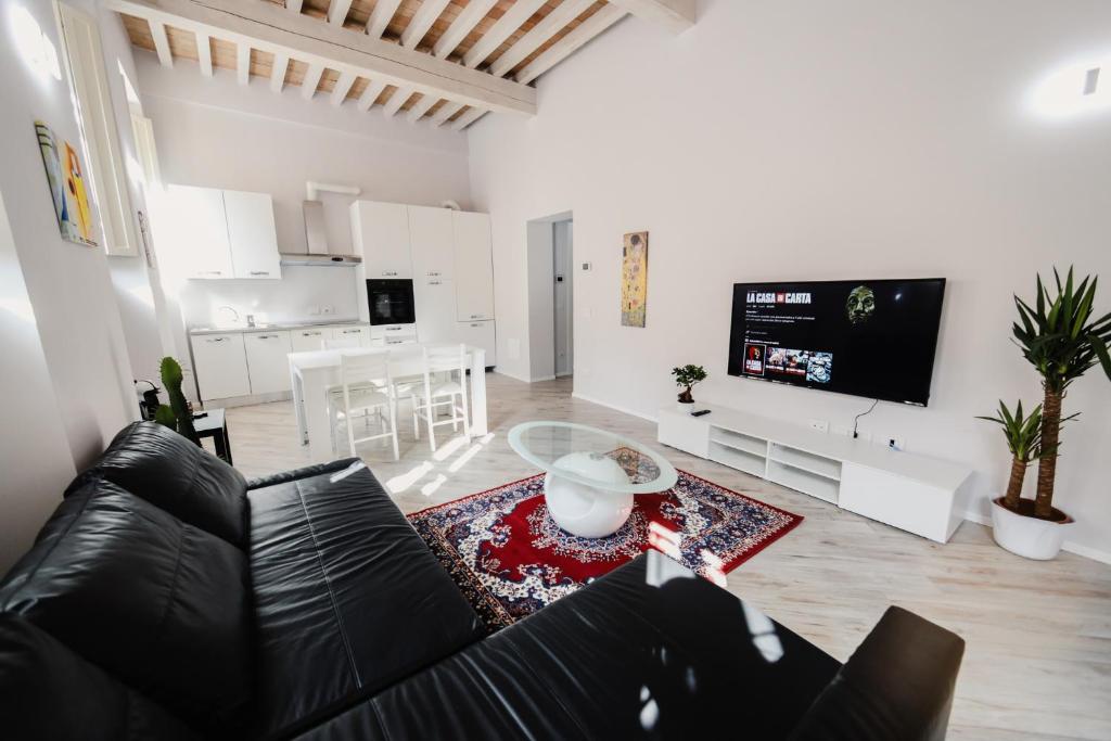 a living room with a black leather couch and a table at [CATHEDRAl] elegant apartment in Parma