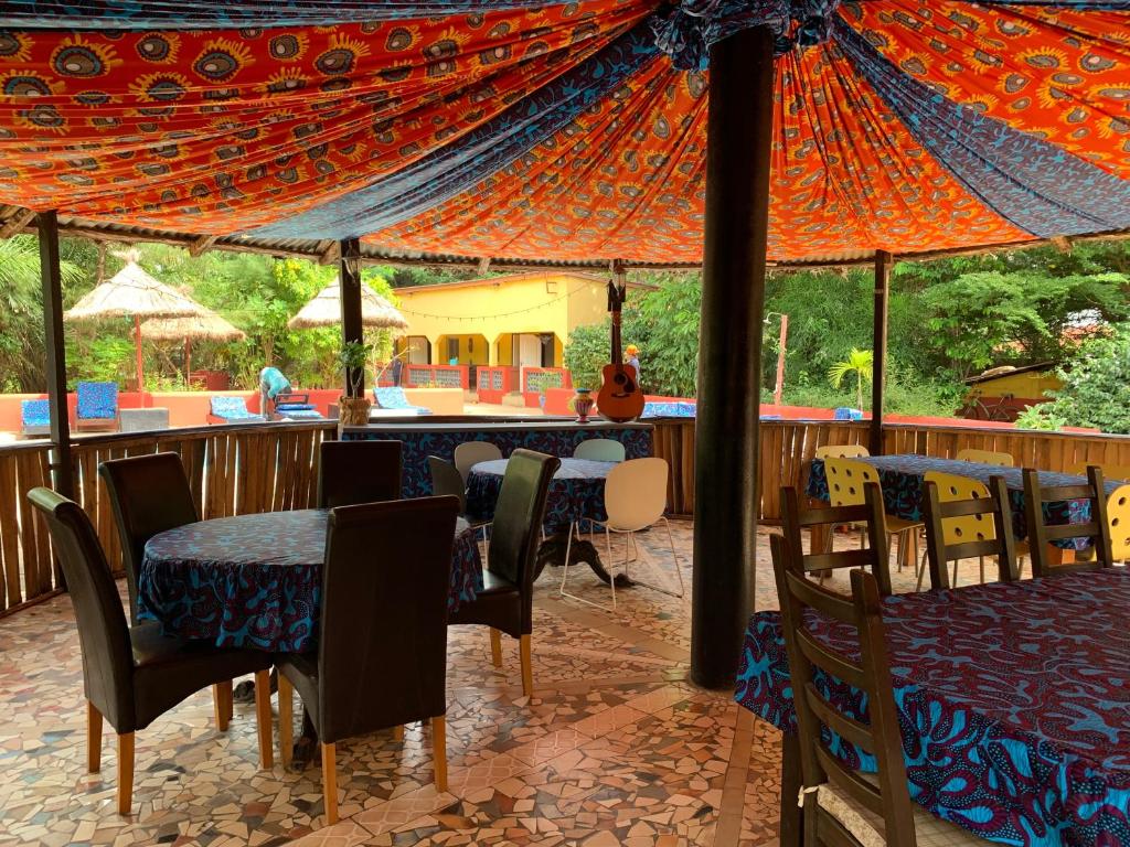 um restaurante com mesas e cadeiras debaixo de uma tenda em The Gunjur Project Lodge em Gunjur