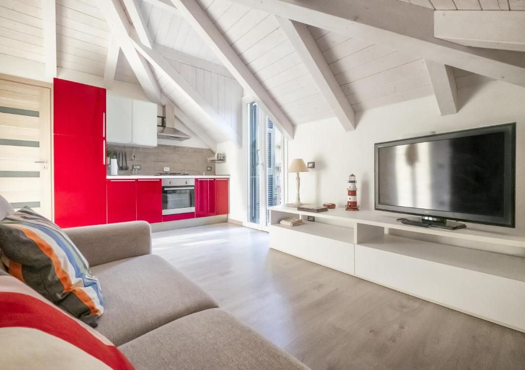 a living room with red cabinets and a flat screen tv at A casa di Oscar in Deiva Marina