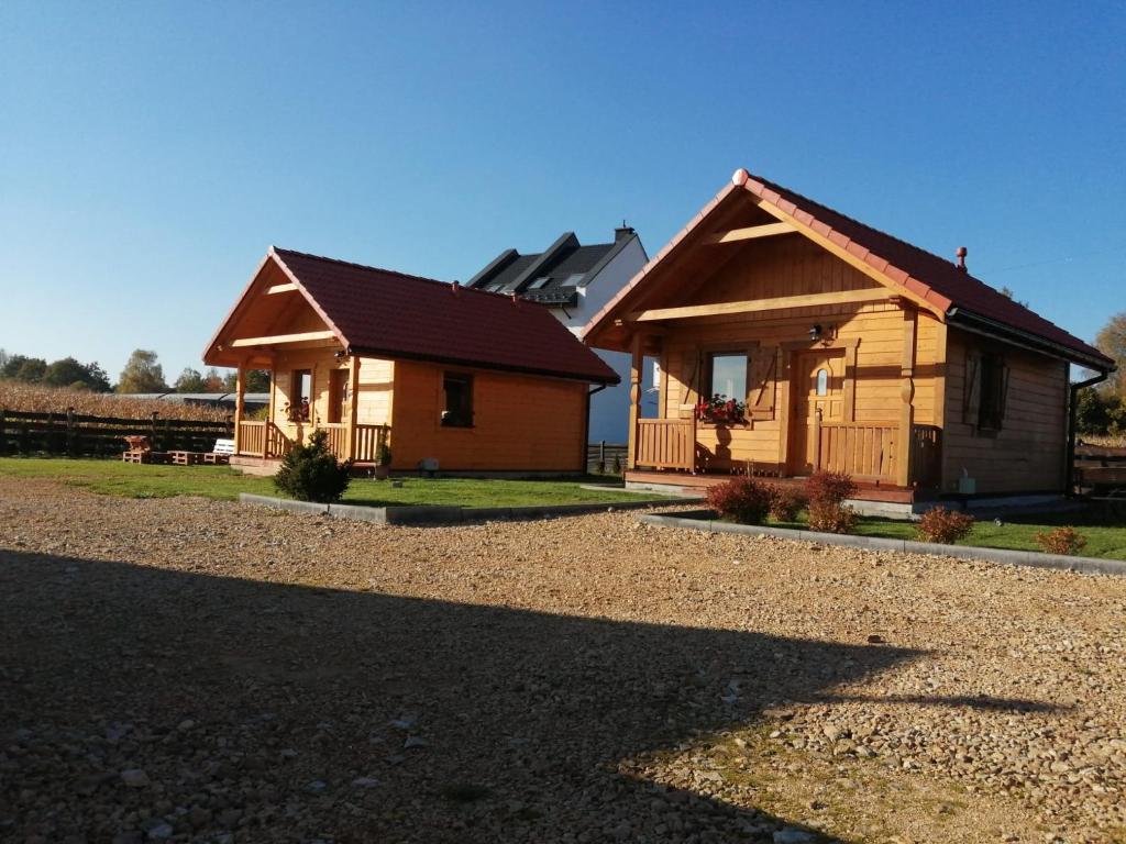 uma casa de madeira com um telhado num quintal em Bella Przystań em Zator