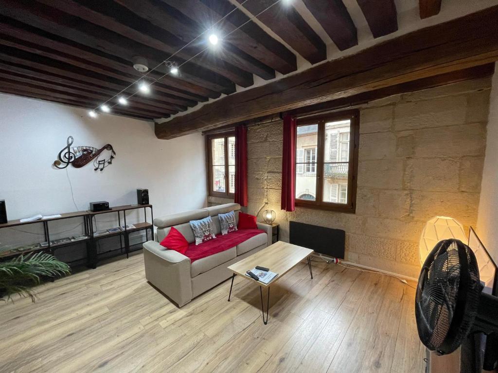 a living room with a couch and a table at Appartements chez Delphine et Guillaume au coeur de Semur en Auxois in Semur-en-Auxois