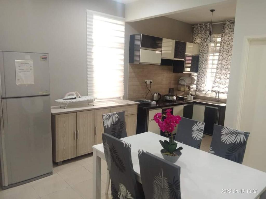 a kitchen with a table with chairs and a refrigerator at Park Villa Homestay in Sungai Petani