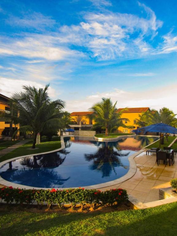 a large pool in a park with palm trees at Riviera de Praia Bela in Pitimbu